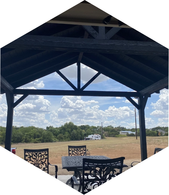 Black patio furniture under a wooden pergola.