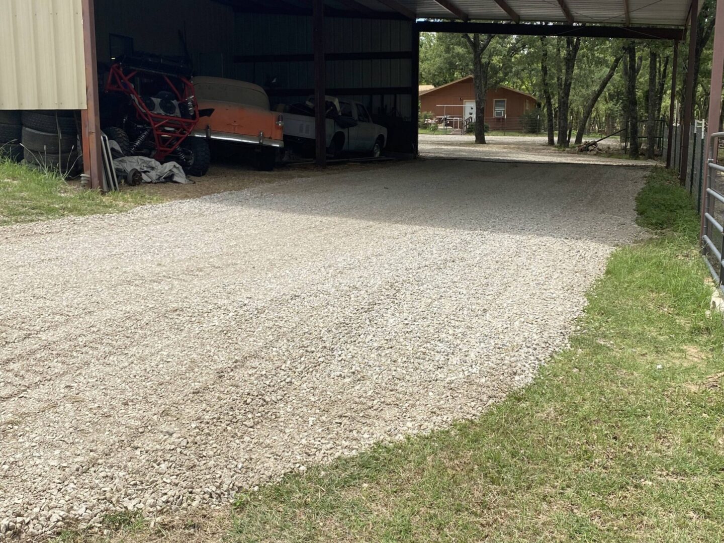 A gravel driveway with a tractor parked in the middle of it.